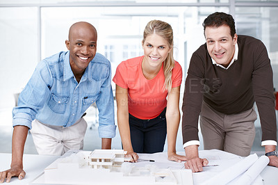 Buy stock photo Portrait of three architects standing by an architectural model