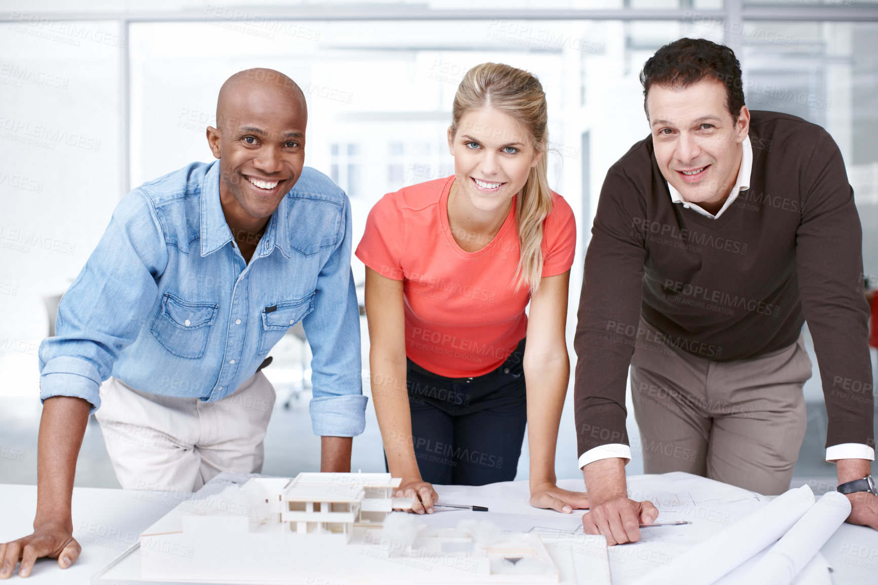 Buy stock photo Portrait of three architects standing by an architectural model