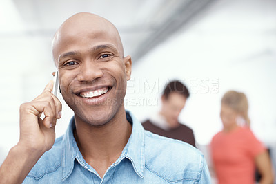 Buy stock photo Portrait of a young businessman talking on his cellphone in the office