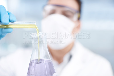 Buy stock photo A chemist pouring chemicals together