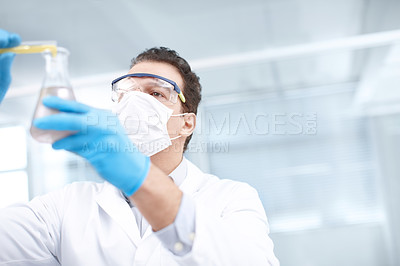 Buy stock photo Low angle shot of a chemist mixing chemicals
