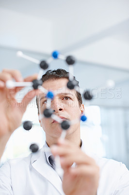 Buy stock photo A scientist looking at a molecular structure model