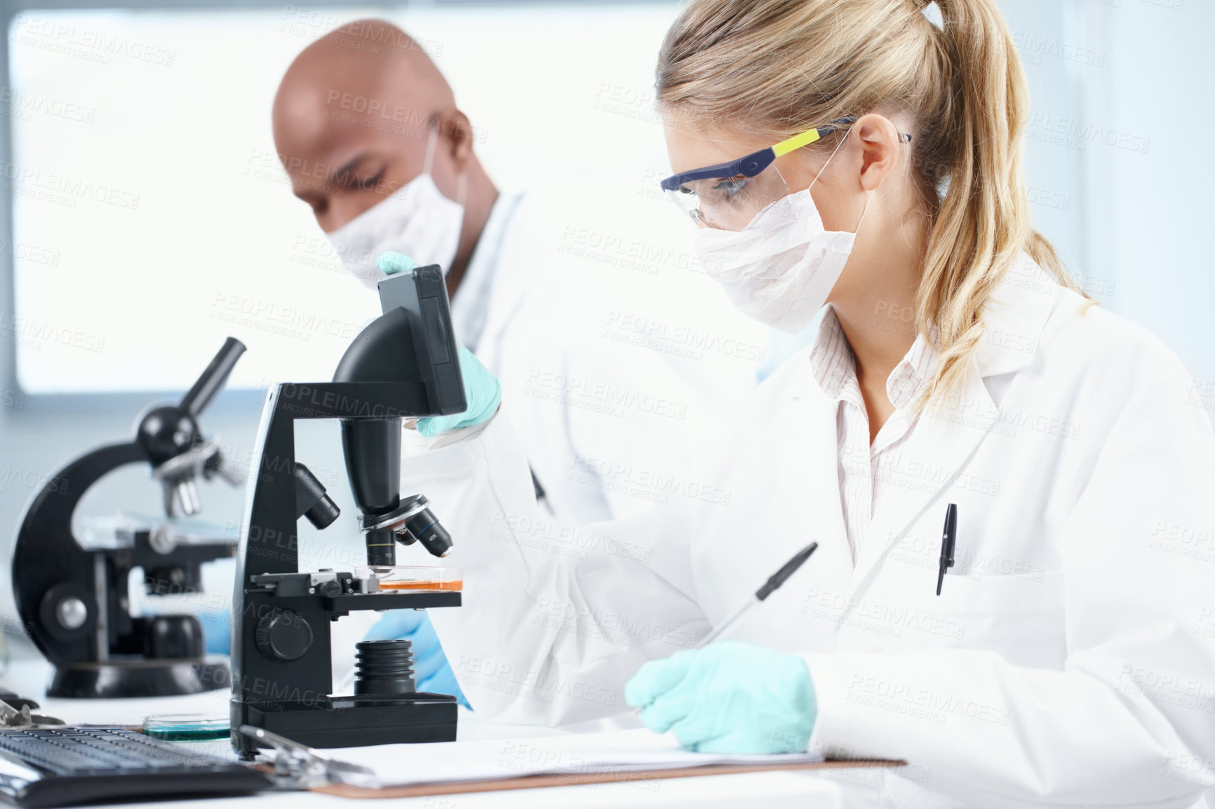 Buy stock photo Mask, man and woman in laboratory with microscope, study and technology in science research. Notes, scientist and medical team with biotech data, pharmaceutical innovation or vaccine development
