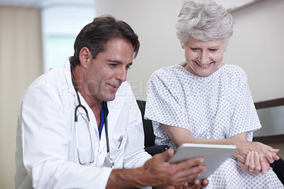 Buy stock photo A male doctor giving his senior patient some good news using his digital tablet