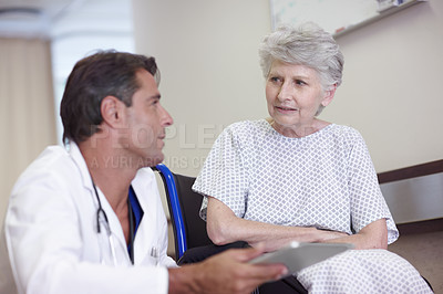 Buy stock photo A male doctor diagnosing his senior patient with the aid of his digital tablet