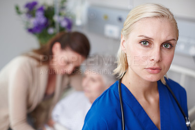 Buy stock photo Portrait of a serious young nurse with a senior patient and her daughter in the background