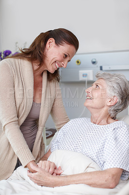Buy stock photo An affectionate daughter visiting her sick mother in the hospital
