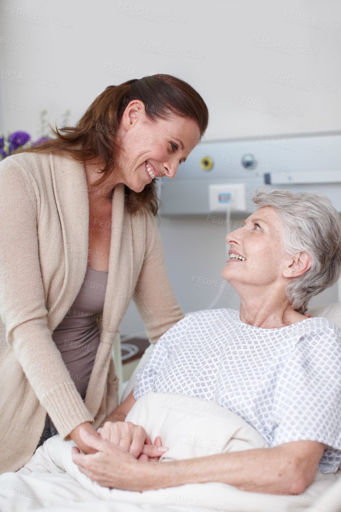 Buy stock photo An affectionate daughter visiting her sick mother in the hospital