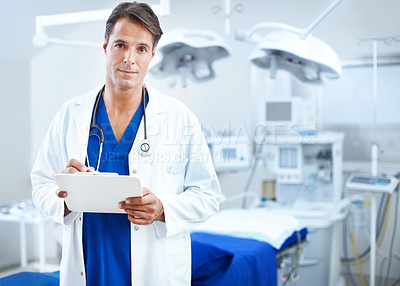 Buy stock photo A confident male doctor holding a chart in the operating room