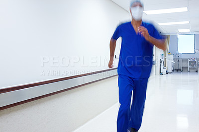Buy stock photo A doctor running in the hallway of a hospital