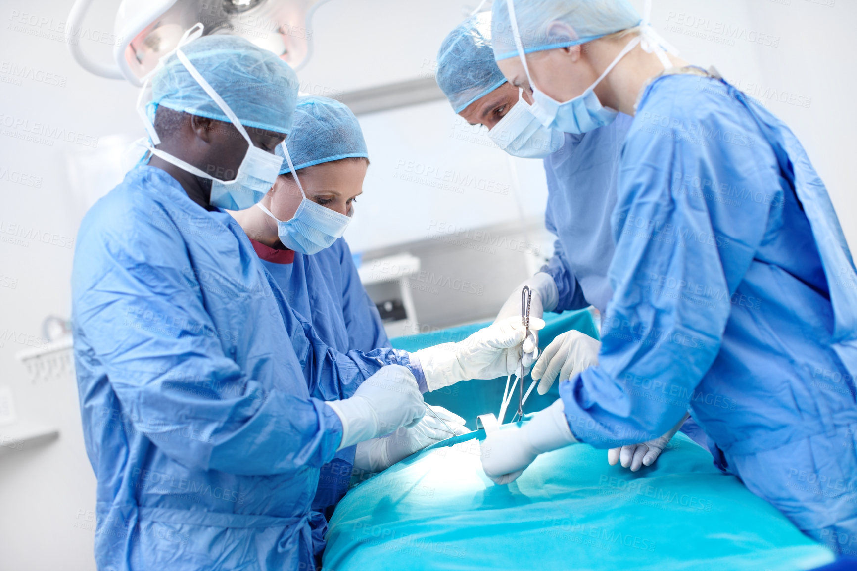 Buy stock photo Surgical doctors operating on a patient in a hospital 