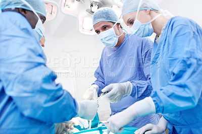 Buy stock photo Low view of medical doctors operating and working together during surgery