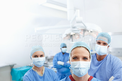 Buy stock photo Portrait of a team of medical surgeons wearing their hospital scrubs and face masks - Copyspace
