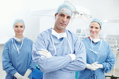 Buy stock photo Portrait of two female nurses and a male doctor wearing hosptial scrubs in an operating room