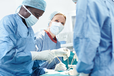 Buy stock photo Diverse group of surgeons operating on a patient in an ER