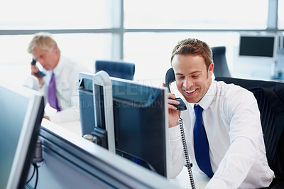 Buy stock photo Handsome business man using telephone at his desk