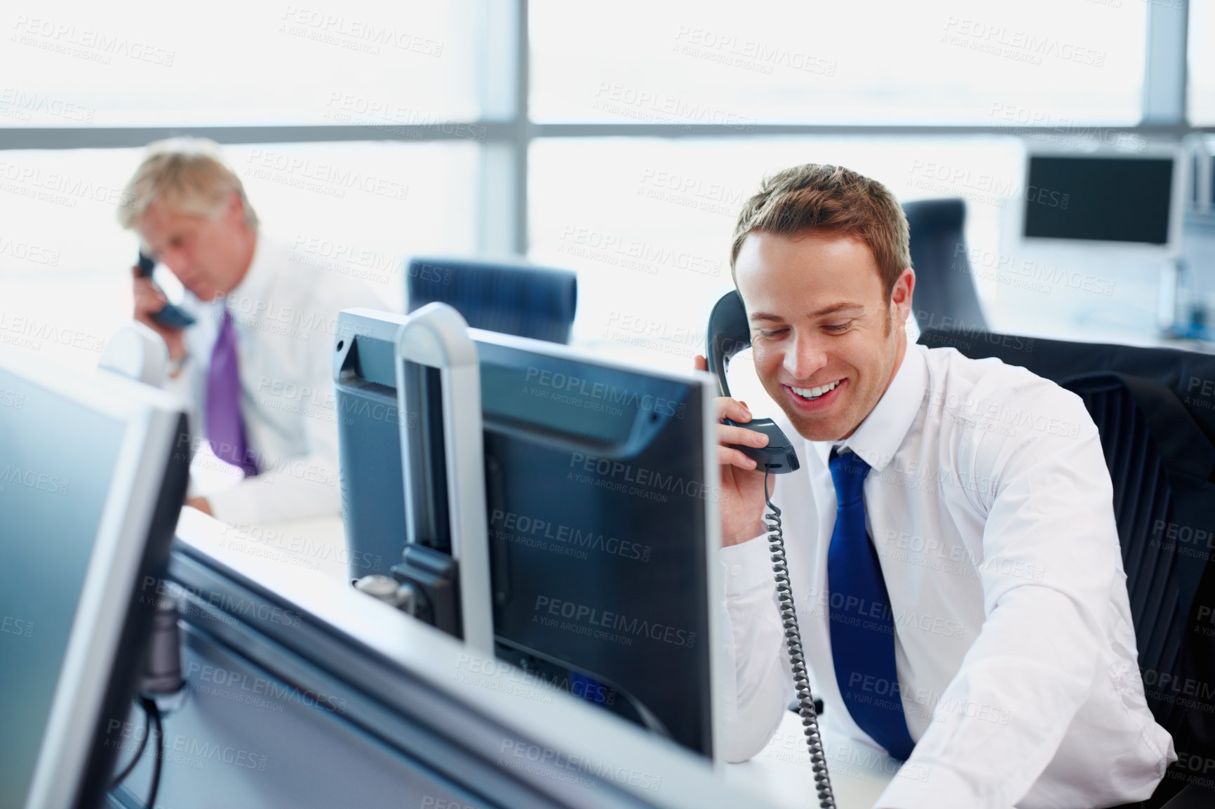 Buy stock photo Handsome business man using telephone at his desk