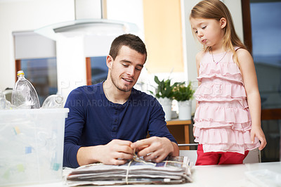 Buy stock photo Recycle, child or dad in home with newspaper for sustainable living, plastics or trash. Eco friendly, donate or father teaching girl, kid or reusable garbage for waste reduction or renewable energy