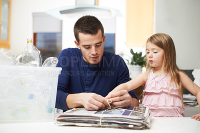 Buy stock photo Father, child and paper in home for recycling, environment care and teach social responsibility. Man, young girl and newspaper in living room for go green, eco drive and kid learning waste reduction