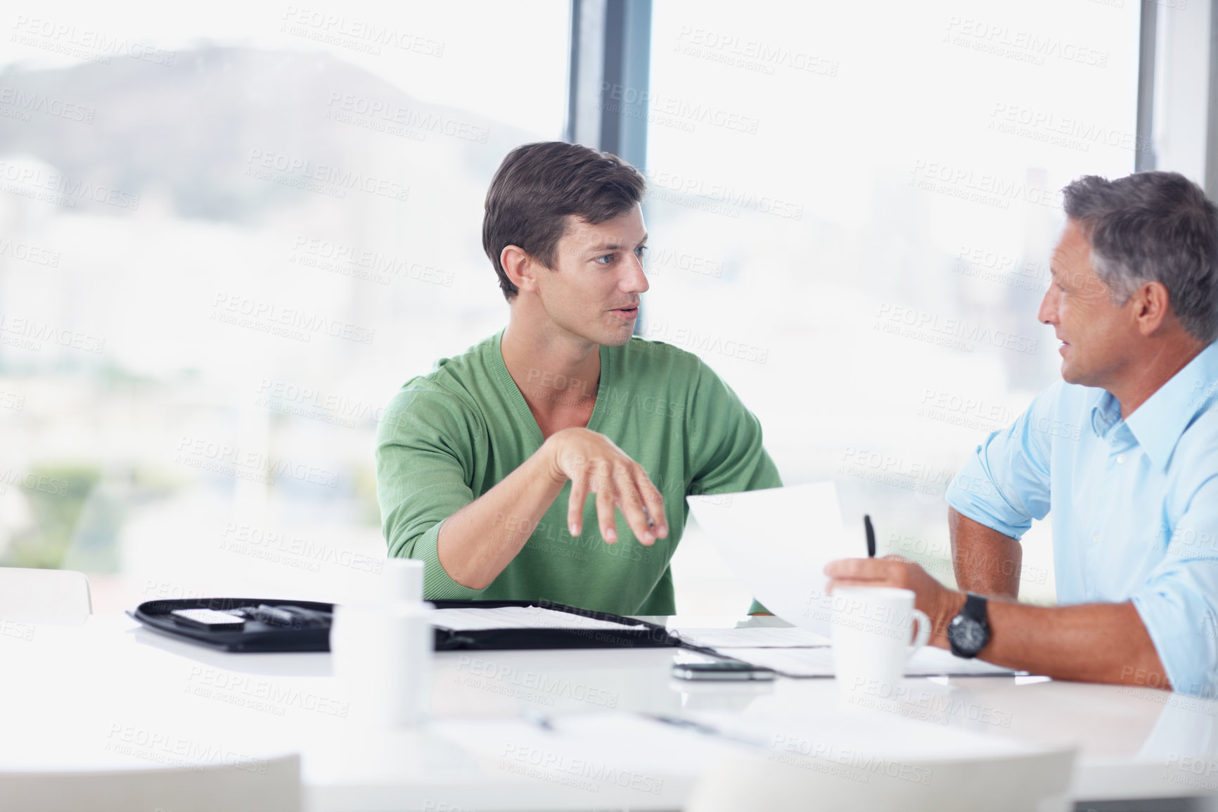 Buy stock photo A young office worker discussing ideas with his boss