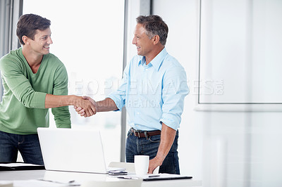 Buy stock photo A mature executive shaking the hand of his younger colleague