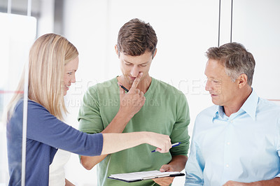 Buy stock photo Three work colleagues discussing something work related