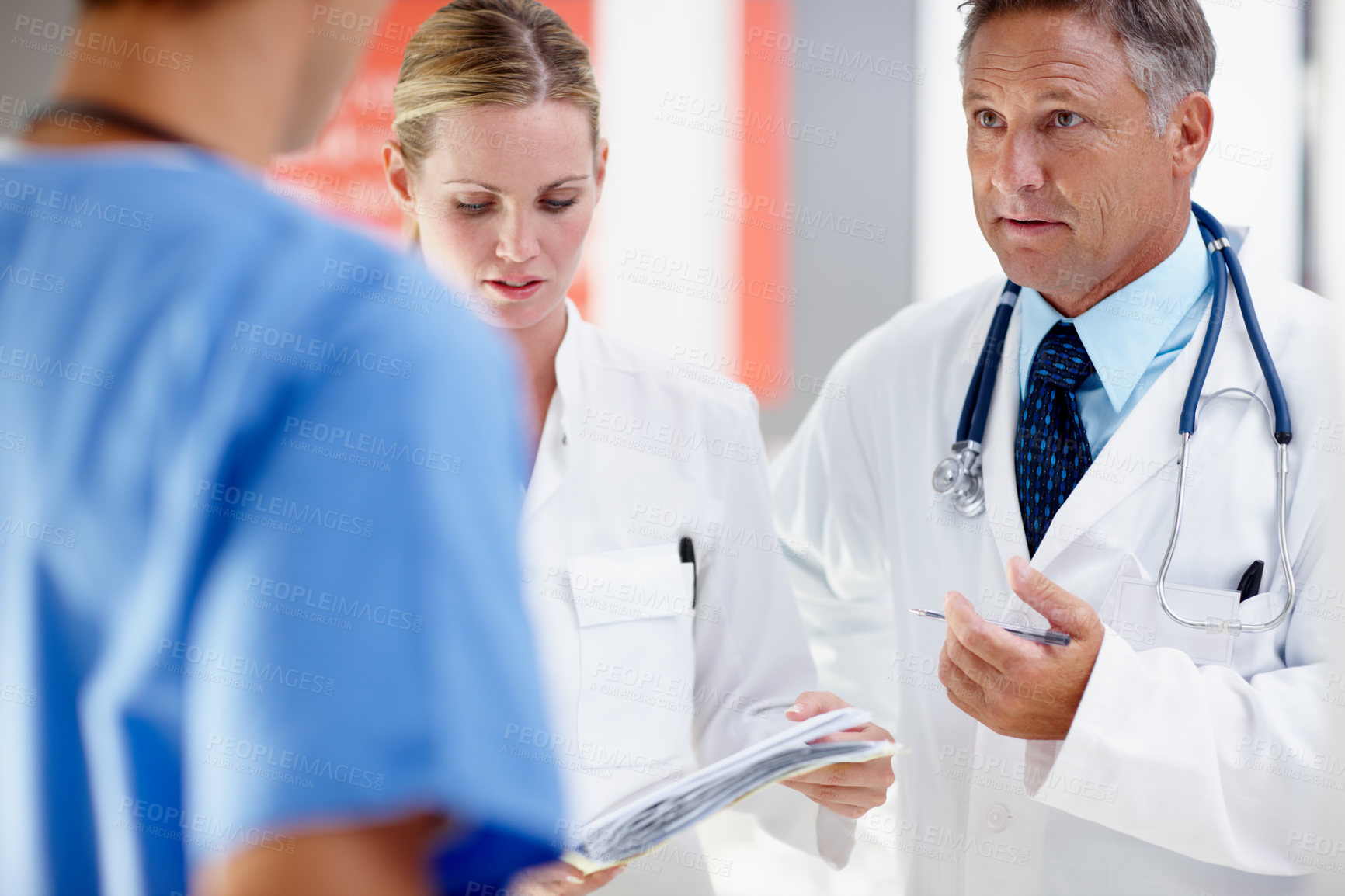 Buy stock photo Three doctors having a serious discussion regarding a patient 