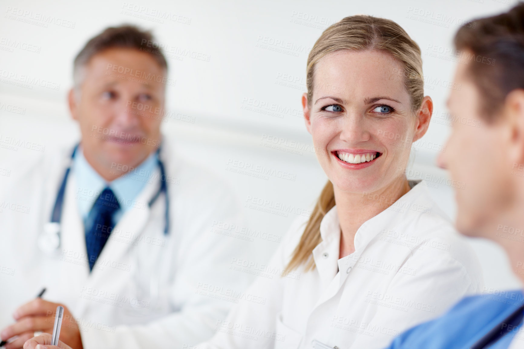 Buy stock photo A pretty doctor listening to a colleague at the boardroom table