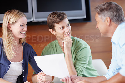 Buy stock photo A young couple getting expert advice from their financial advisor