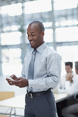 Buy stock photo A handsome african businessman, text messaging and smiling