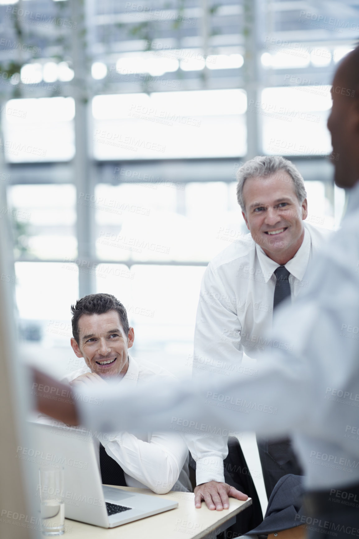 Buy stock photo Businessmen smile and watch as a colleague delivers a presentation on a flipchart