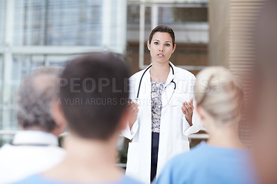 Buy stock photo A doctor delivering a speech in front of some coworkers