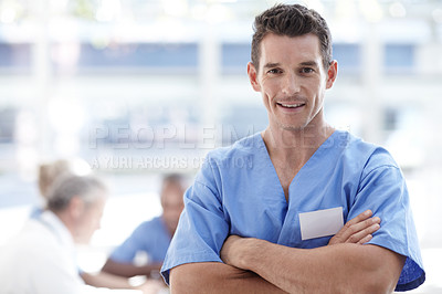 Buy stock photo Medical professional standing with arms crossed and colleagues sitting in the background