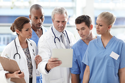 Buy stock photo Team of medical professionals looking at touchpad