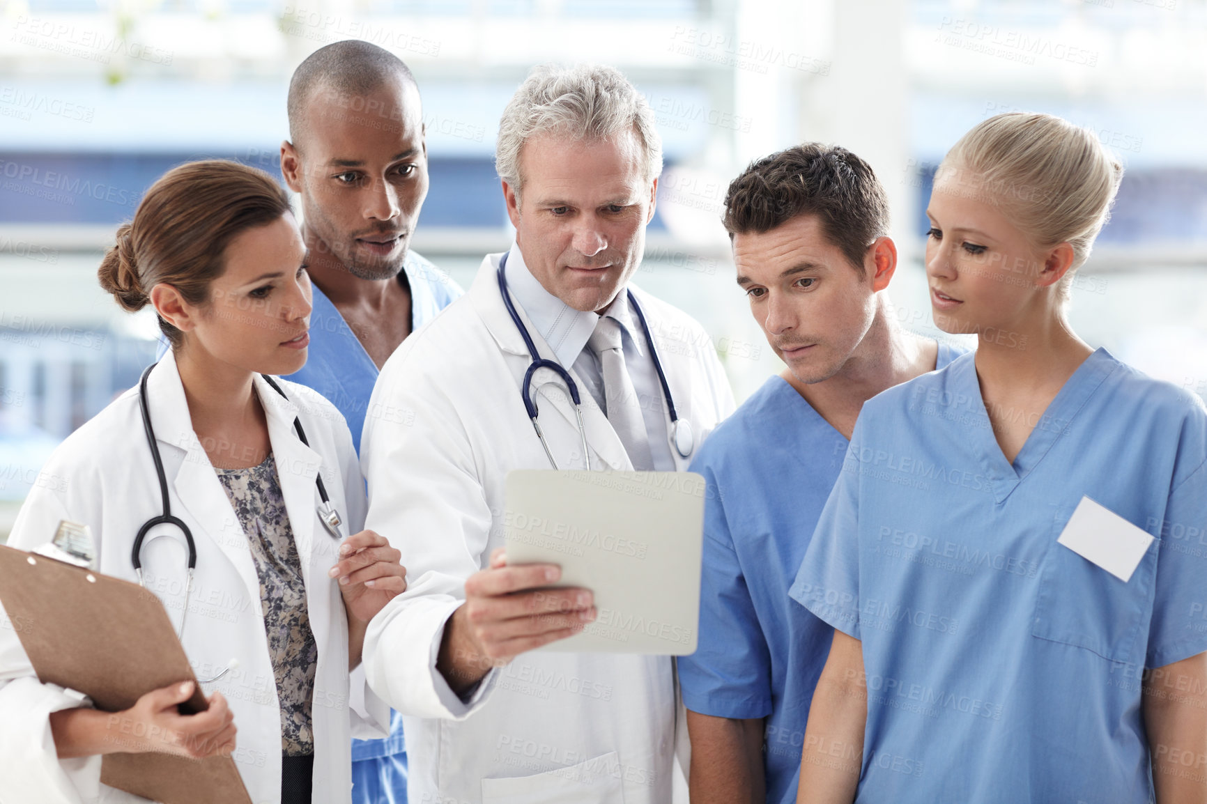 Buy stock photo Team of medical professionals looking at touchpad