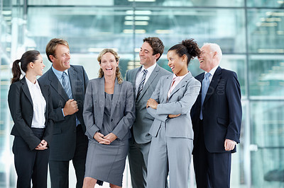 Buy stock photo Happy group of businesspeople standing together and smiling while surrounding a coworker - portrait 