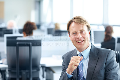 Buy stock photo Laughing mature businessman sitting working on a computer in the office - portrait 