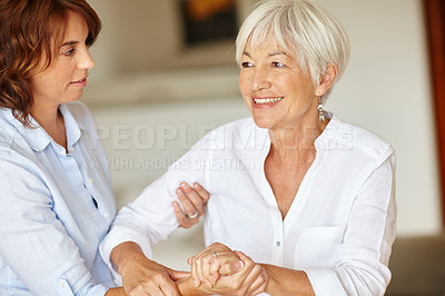 Buy stock photo Shot of a woman assisting her elderly mother