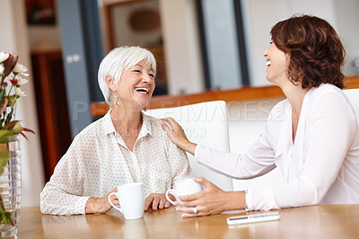Buy stock photo Shot of a senior woman and her daughter chatting over coffee