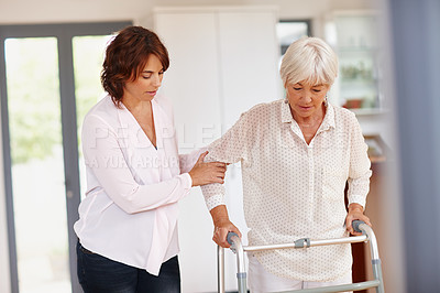 Buy stock photo Shot of a woman assisting her elderly mother with an orthopedic walker