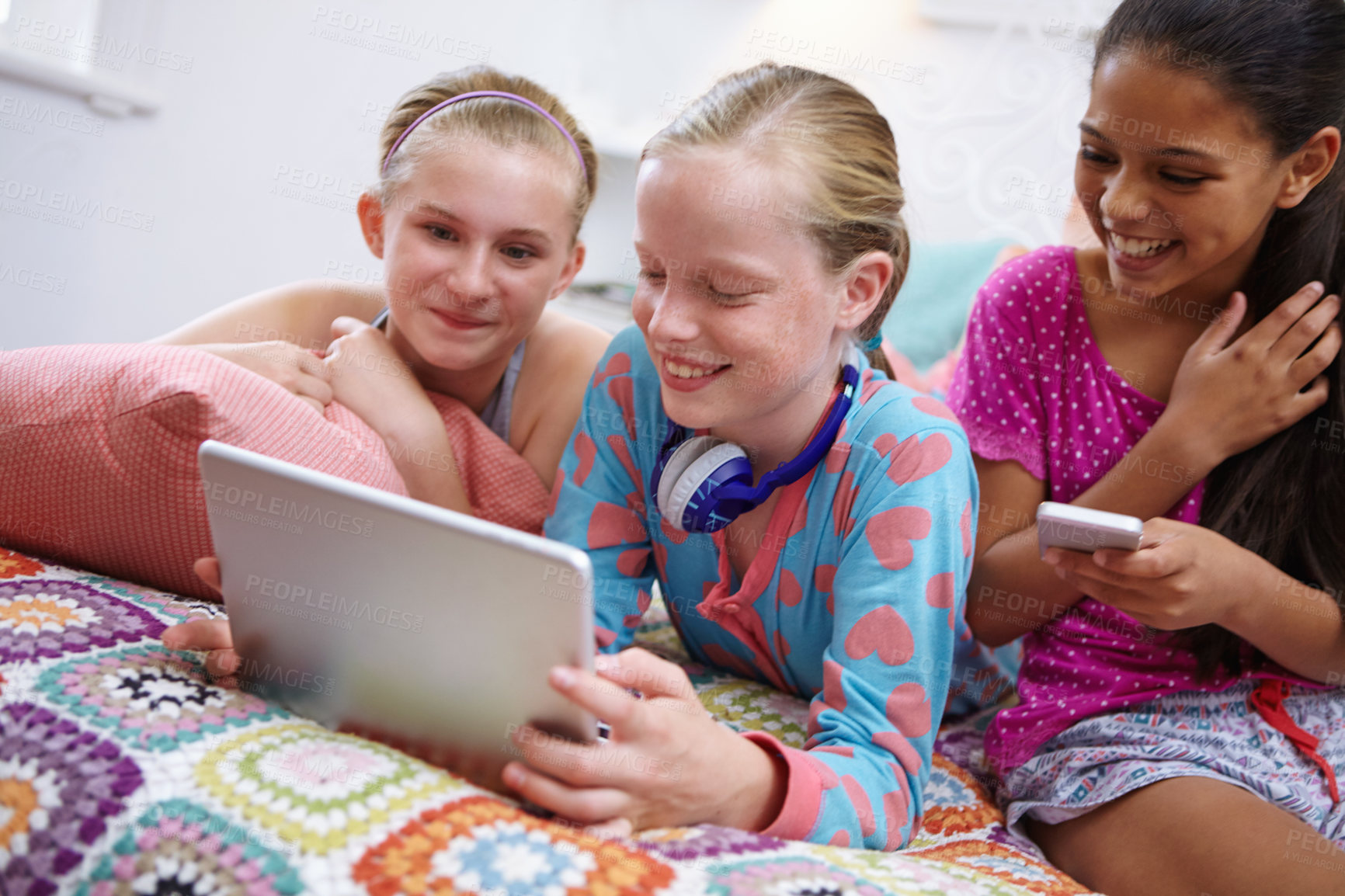 Buy stock photo Shot of a group of teenage friends using a digital tablet together