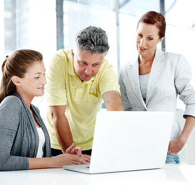 Buy stock photo A group of businesspeople working together as a team at a laptop