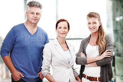 Buy stock photo A group of three casual businesspeople standing next to each other in a row- waist up