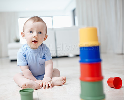 Buy stock photo A playful baby boy sitting on the living room floor