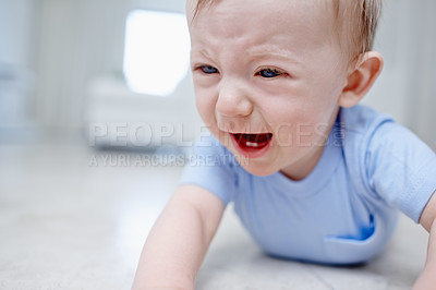 Buy stock photo Closeup of a very unhappy baby boy lying on the floor