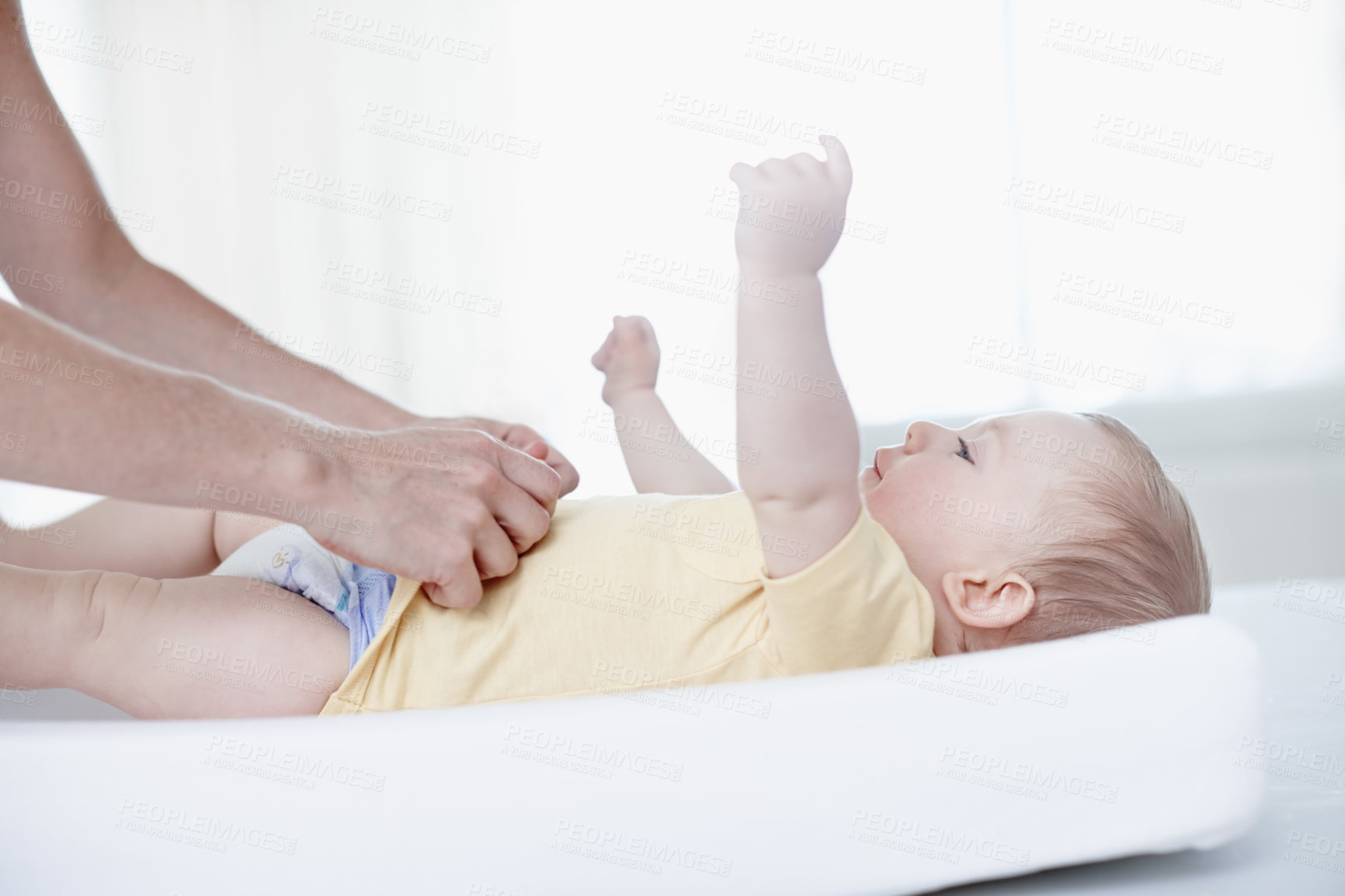 Buy stock photo A cute baby boy being changed by his mother