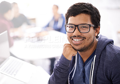 Buy stock photo Portrait of a happy young man working on his laptop in an office