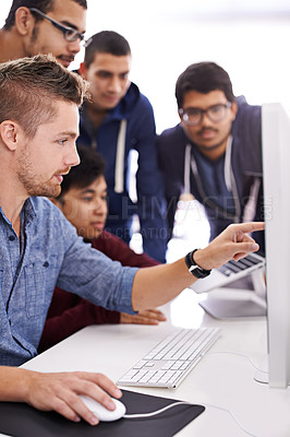 Buy stock photo Shot of a group of colleagues working together with a computer in an office