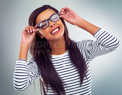 Buy stock photo Studio, glasses and portrait of girl with eye care for clear vision, optometry and confidence. Playful, spectacles and smile with happiness for eyesight, pride and wellness on gray background