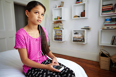 Buy stock photo Shot of a teenage girl listening to music in her bedroom